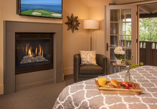 a hotel room with a fireplace and a tray of food on a bed at Carmel Country Inn in Carmel