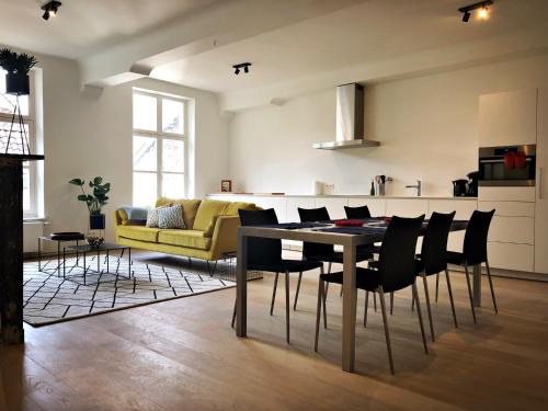a living room with a dining table and a yellow couch at Bed & Boon in Ghent
