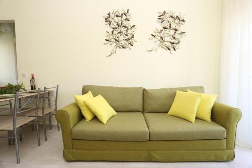 a green couch with yellow pillows in a living room at Elia in Skála Foúrkas