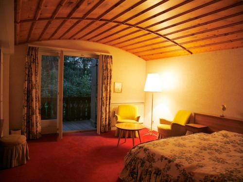 ヴェルビエにあるArche de Noé B&Bのベッド、テーブル、椅子が備わるホテルルームです。