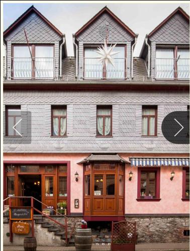 a building with a clock on top of it at Das Loreley Weinstuebchen in Sankt Goarshausen