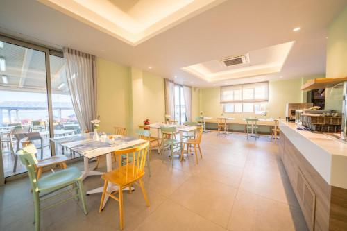 a dining room with tables and chairs and windows at Adele Beach Hotel in Adelianos Kampos