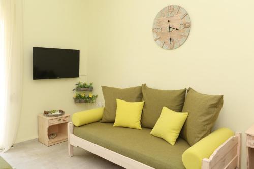 a living room with a green couch with yellow pillows at Elia in Skála Foúrkas