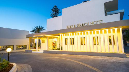 a building with a parking lot in front of it at Adele Beach Hotel in Adelianos Kampos