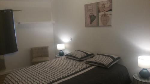 een slaapkamer met een bed met 2 lampen en een stoel bij Mistral in Saint-Jean-de-Fos