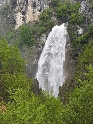 a waterfall on the side of a mountain at Detached house Milivoje in Pošćenje