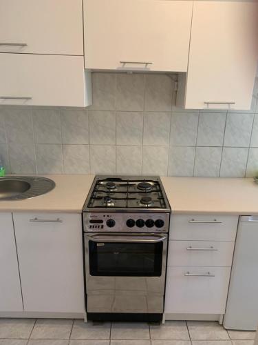 a kitchen with a stove and white cabinets at Mieszkanie w Centrum in Gdynia