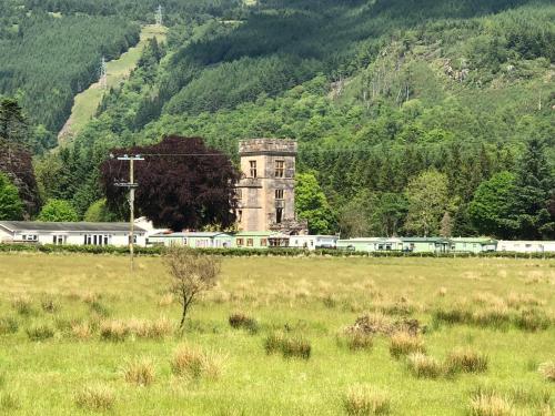 an old building in a field with a train at Swift Bordeaux Sea View 15 in Dunoon