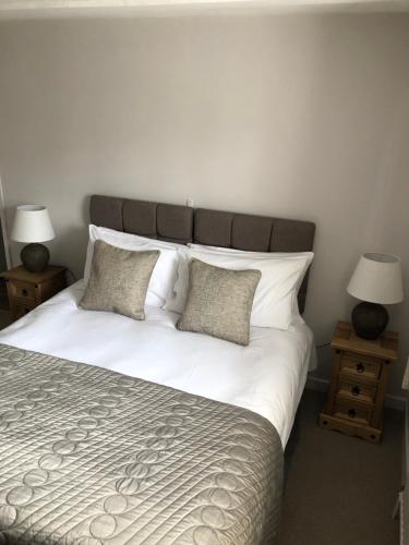a bedroom with a large white bed with pillows at The George at Nunney in Frome