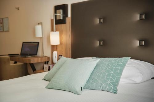 a bedroom with a bed with a laptop on a desk at Pont du Chalon Hôtel and Restaurant in Margès