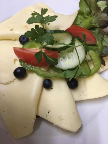 a plate of cheese with a salad and vegetables at Das Loreley Weinstuebchen in Sankt Goarshausen