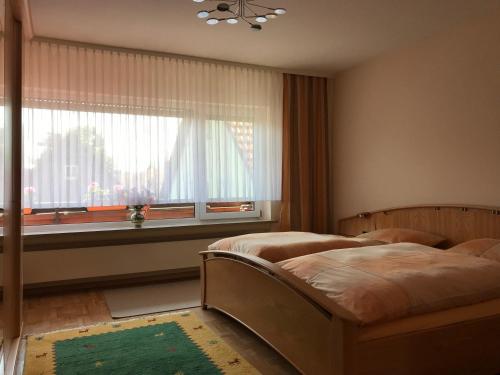 1 dormitorio con 2 camas y ventana en Ferienwohnung Leonhard Müller, en Marktrodach