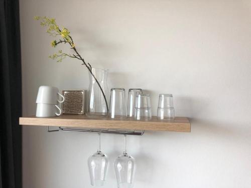 a wooden shelf with glasses and a vase on it at Marina Strand Appartement Lemmer in Lemmer