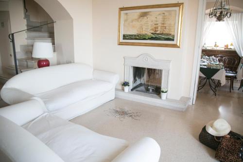 a living room with two white couches and a fireplace at La Dolce Vista - B&B di Charme in Manfredonia
