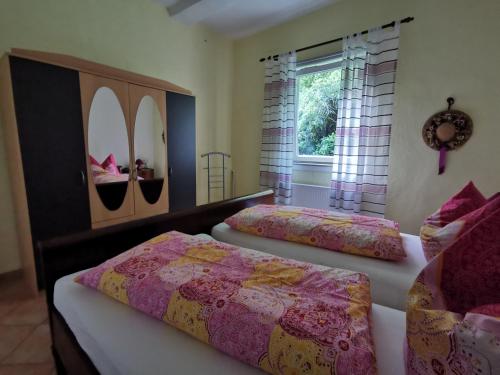 a bedroom with two beds and a window with surfboards at Ferienhof Ehlers in Hülsede