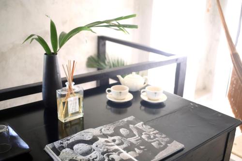 a black table with a book and cups and a plant at Coqui Coqui Papholchac Coba Residence & Spa in Cobá