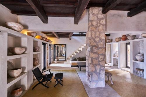 a large living room with a stone pillar and chairs at Coqui Coqui Papholchac Coba Residence & Spa in Cobá