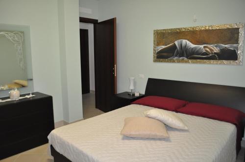 a bedroom with a bed with red pillows and a painting at La terrazza da Barbara in Torrita di Siena