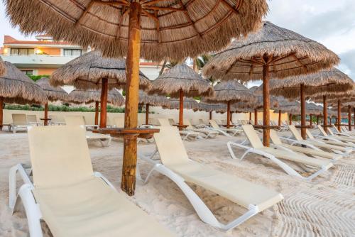 a group of chairs and umbrellas on a beach at Wyndham Grand Cancun All Inclusive Resort & Villas in Cancún