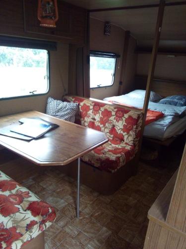 a room with a table and a couch and a bed at ferme pedagogique des pennetieres in Montcorbon