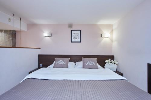 a bedroom with a large bed with two pillows at Langery Residence Central Apartments in Odesa