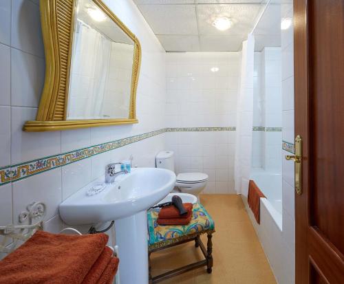 y baño con lavabo, aseo y espejo. en El Rico Rincón de Sanlúcar la Mayor, en Sanlúcar la Mayor