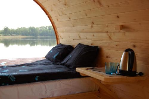 a bed in the back of a wooden boat at Ezermala in Valdemārpils