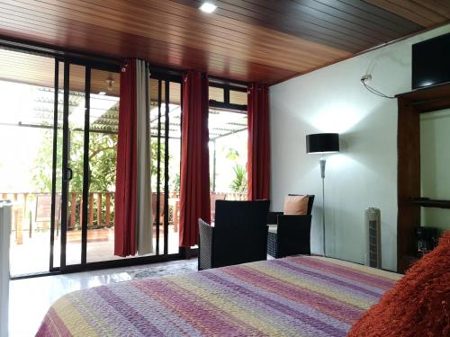 a bedroom with a bed and a large window at La Guayaba Monteverde in Monteverde Costa Rica
