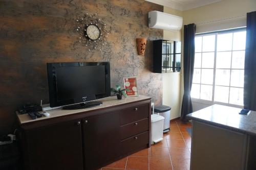 a living room with a flat screen tv on a dresser at Vau Seaview Apartment in Portimão