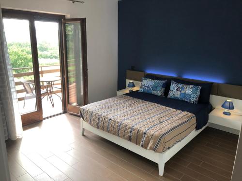 a bedroom with a bed with a blue wall at B&B Artemide in Agropoli