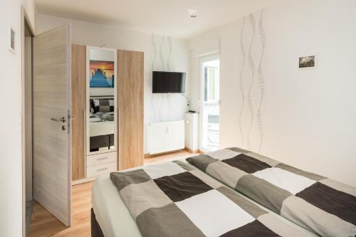 a bedroom with a bed and a tv on a wall at FeWo-tt 2 in Traben-Trarbach