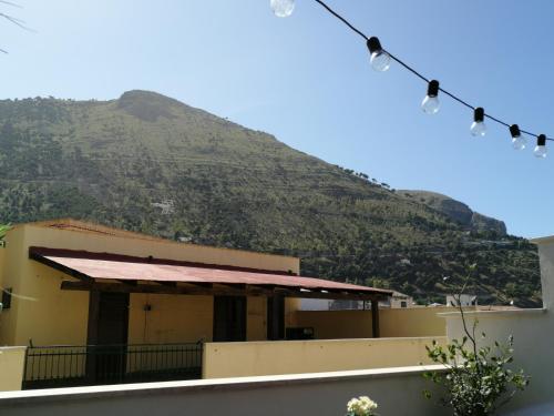 a building with a mountain in the background with lights at Atrium in Castellammare del Golfo