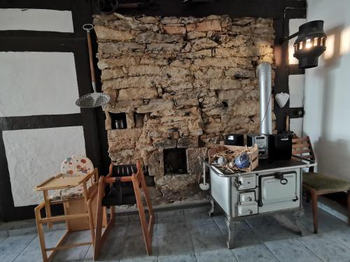a room with a stone wall and a table and chairs at Ferienhof Ehlers in Hülsede