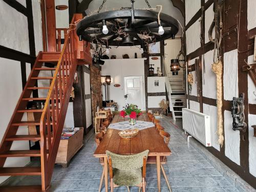a dining room with a wooden table and stairs at Ferienhof Ehlers in Hülsede