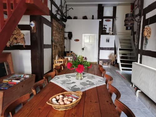 a dining room with a wooden table and a basket of eggs at Ferienhof Ehlers in Hülsede