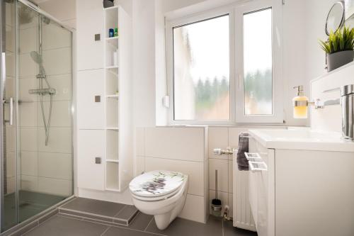 a white bathroom with a toilet and a sink at FeWo-tt 2 in Traben-Trarbach