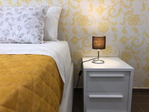 a bed with a night stand with a lamp on it at B&B Artemide in Agropoli
