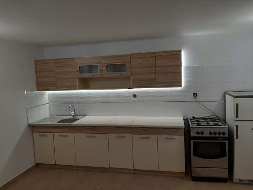 a kitchen with a sink and a stove and cabinets at Agroturystyka Tylmanowa in Tylmanowa