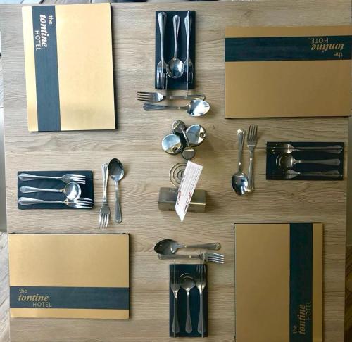 a group of utensils on a wooden table at The Tontine Hotel in Greenock