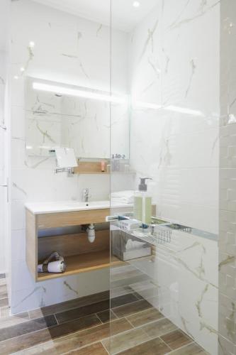 a bathroom with a sink and a glass shower at Pont du Chalon Hôtel and Restaurant in Margès