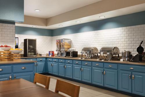 a large kitchen with blue cabinets and a table at Country Inn & Suites by Radisson, Nashville Airport East, TN in Nashville