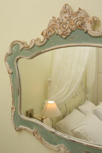 a mirror in a bedroom with a bed and a lamp at Elia in Skála Foúrkas