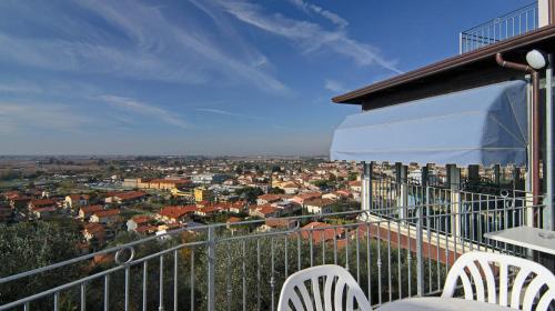 a balcony with chairs and a view of a city at La Chandelle in Massarosa