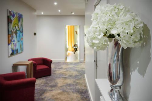 a vase filled with white flowers on a wall at Pont du Chalon Hôtel and Restaurant in Margès
