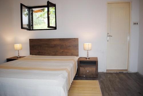 - une chambre avec un lit et 2 tables de nuit avec des lampes dans l'établissement Hit apartment, à Sevid