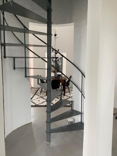 a spiral staircase in a room with a table at Ystads Gamla Vattentorn in Ystad