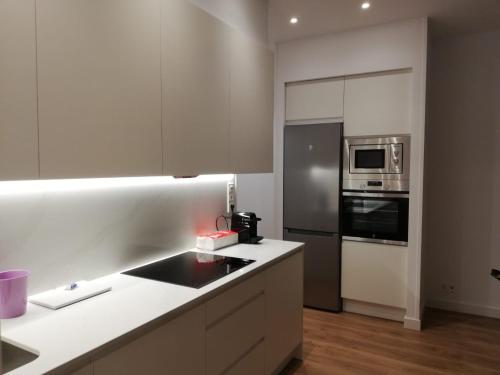 kuchnia z białymi blatami i piekarnikiem w obiekcie ARENA Apartamento - Perla Boutique Apartamentos w mieście San Sebastián