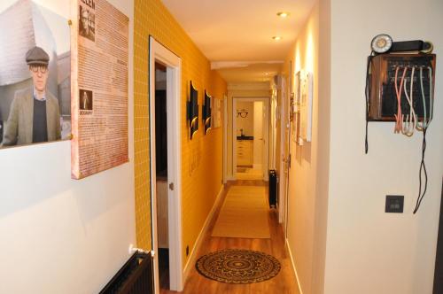 a hallway with yellow walls and wooden floors at Pensión Boutique Caravan Cinema in Bilbao