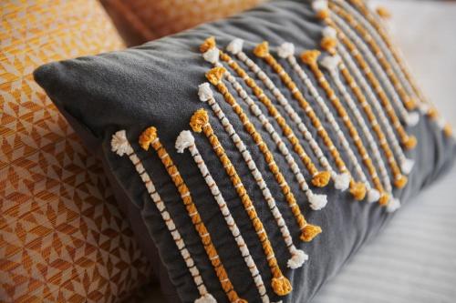 a close up of a pillow on a couch at Pont du Chalon Hôtel and Restaurant in Margès