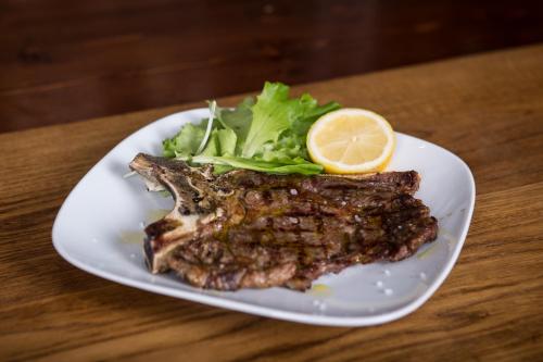 a piece of steak with a lemon on a plate at Dal Patricano in Frosinone